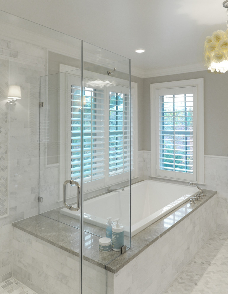 Modern inredning av ett badrum, med ett undermonterad handfat, luckor med upphöjd panel, vita skåp, ett hörnbadkar, en hörndusch och grå väggar