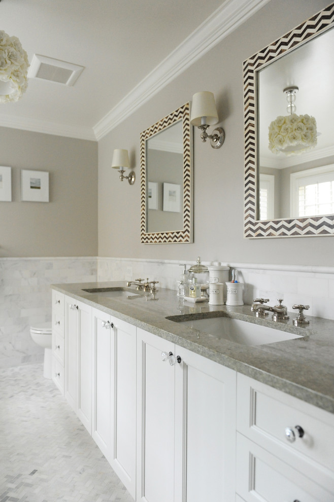 На фото: ванная комната в стиле неоклассика (современная классика) с врезной раковиной, фасадами с утопленной филенкой, белыми фасадами, белой плиткой, серыми стенами, полом из мозаичной плитки и серой столешницей