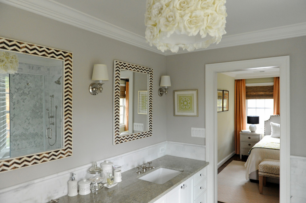 Cette image montre une salle de bain design avec un lavabo encastré, un placard avec porte à panneau encastré, des portes de placard blanches, un mur gris et un carrelage blanc.