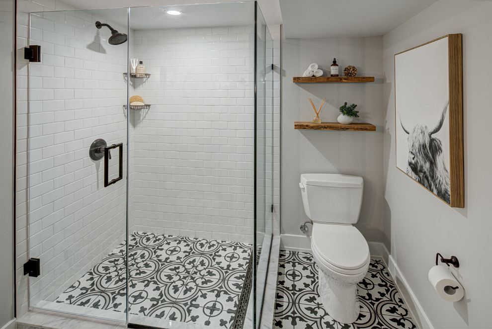 Inspiration för små rustika en-suite badrum, med en hörndusch, en toalettstol med separat cisternkåpa, vit kakel, tunnelbanekakel, vita väggar, cementgolv, flerfärgat golv och dusch med gångjärnsdörr