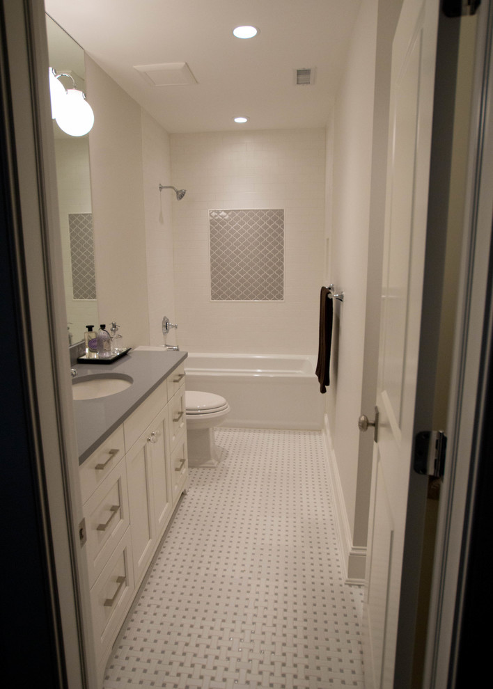 Inredning av ett amerikanskt stort badrum för barn, med luckor med infälld panel, marmorbänkskiva, ett platsbyggt badkar, flerfärgad kakel, stenkakel, vita väggar, marmorgolv och vita skåp