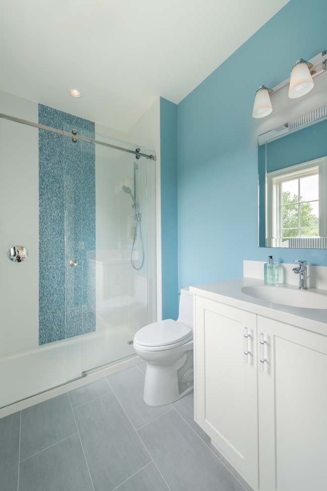 Cette photo montre une salle de bain chic de taille moyenne avec un placard avec porte à panneau encastré, des portes de placard blanches, une douche ouverte, un carrelage bleu, un carrelage en pâte de verre, un sol en carrelage de porcelaine, un mur bleu et un lavabo encastré.