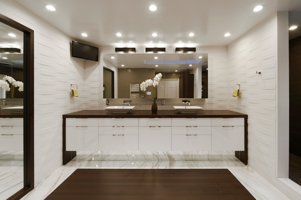 Idéer för stora funkis brunt en-suite badrum, med ett fristående handfat, släta luckor, vita skåp, vita väggar, marmorgolv, en toalettstol med hel cisternkåpa, vit kakel, stenkakel och träbänkskiva