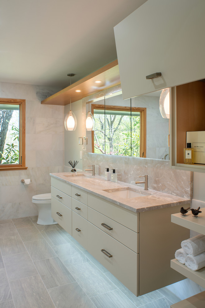 Bathroom - large contemporary master beige tile and marble tile linoleum floor and beige floor bathroom idea in DC Metro with flat-panel cabinets, beige cabinets, beige walls, an undermount sink, marble countertops, a hinged shower door, beige countertops and a one-piece toilet