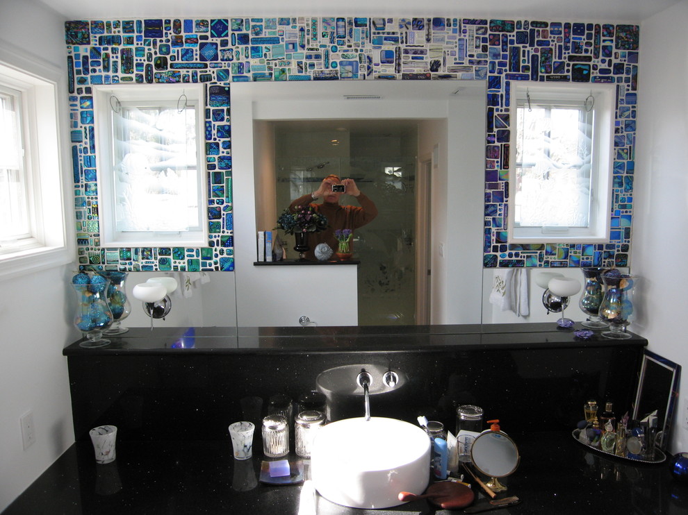 Modern inredning av ett en-suite badrum, med luckor med infälld panel, skåp i mörkt trä, en dusch i en alkov, en toalettstol med hel cisternkåpa, svart kakel, glaskakel, vita väggar, klinkergolv i keramik, ett fristående handfat och marmorbänkskiva