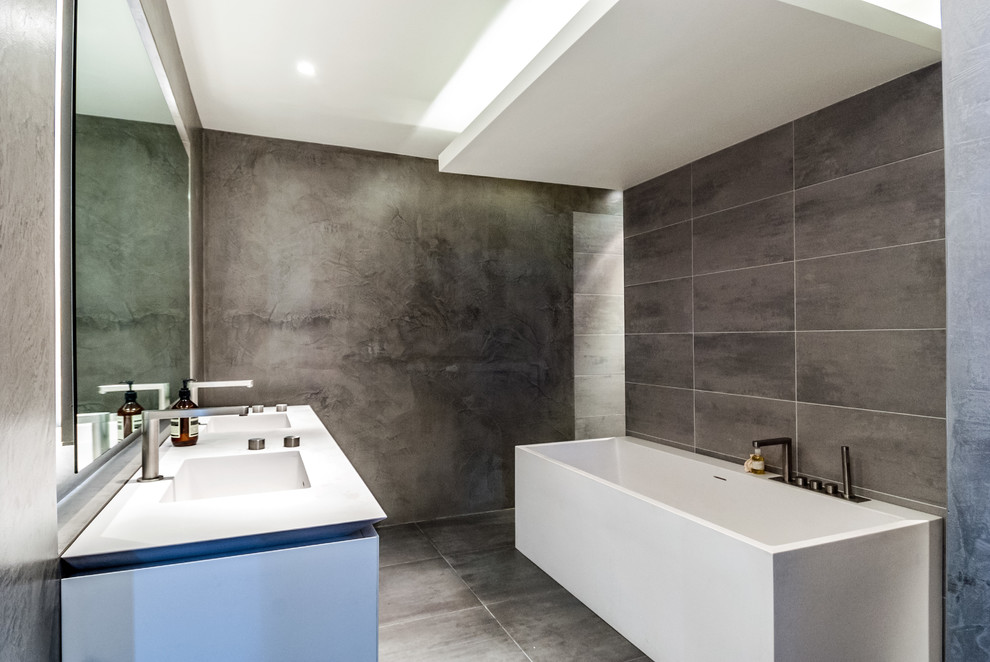 Idées déco pour une douche en alcôve grise et blanche contemporaine avec un lavabo intégré, un carrelage gris, des carreaux de béton, un mur gris et sol en béton ciré.