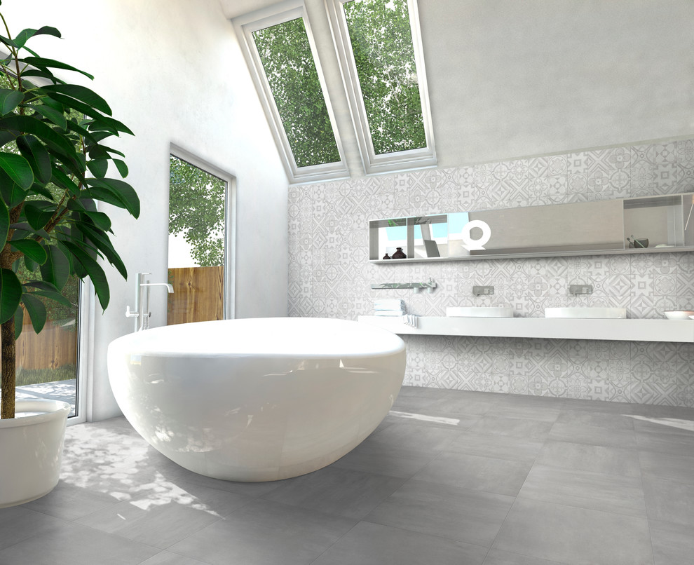 Modelo de cuarto de baño contemporáneo con suelo de baldosas de porcelana, lavabo sobreencimera, bañera exenta y baldosas y/o azulejos grises