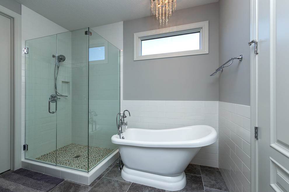 This is an example of a medium sized classic ensuite bathroom in Chicago with a freestanding bath, a corner shower, white tiles, metro tiles, grey walls, ceramic flooring, grey floors and a hinged door.