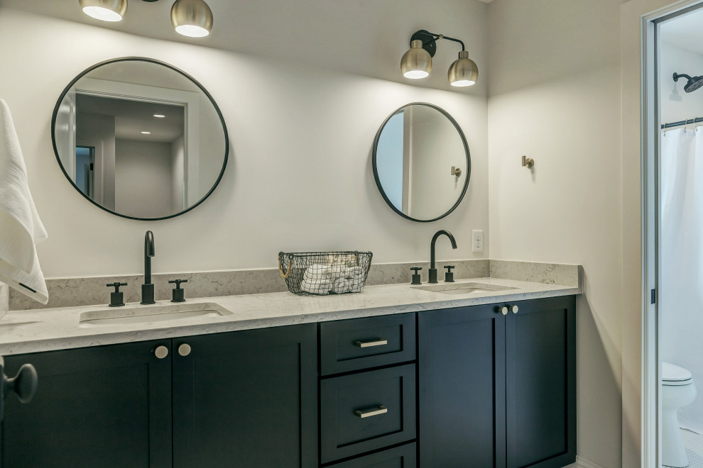 Aménagement d'une salle de bain principale classique de taille moyenne avec un placard à porte shaker, des portes de placard noires, un mur gris, un lavabo encastré, un plan de toilette en granite et un plan de toilette gris.
