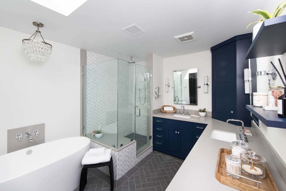 Modern inredning av ett stort grå grått en-suite badrum, med skåp i shakerstil, blå skåp, ett fristående badkar, en hörndusch, en toalettstol med hel cisternkåpa, grå kakel, marmorkakel, vita väggar, klinkergolv i porslin, ett nedsänkt handfat, bänkskiva i kvarts, grått golv och dusch med gångjärnsdörr