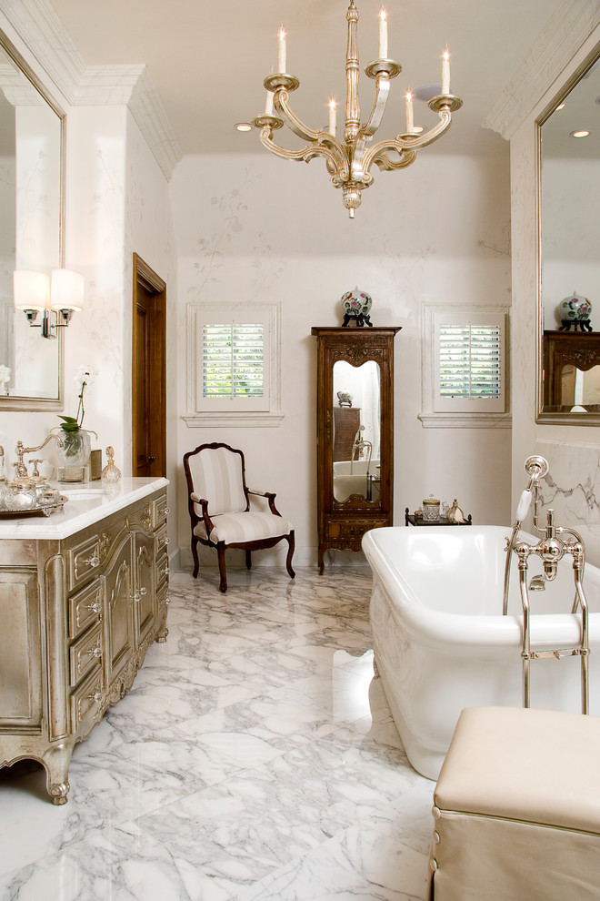 Esempio di un'ampia stanza da bagno padronale tradizionale con lavabo da incasso, consolle stile comò, ante con finitura invecchiata, top in marmo, vasca freestanding, piastrelle bianche, lastra di pietra, pareti bianche e pavimento in marmo