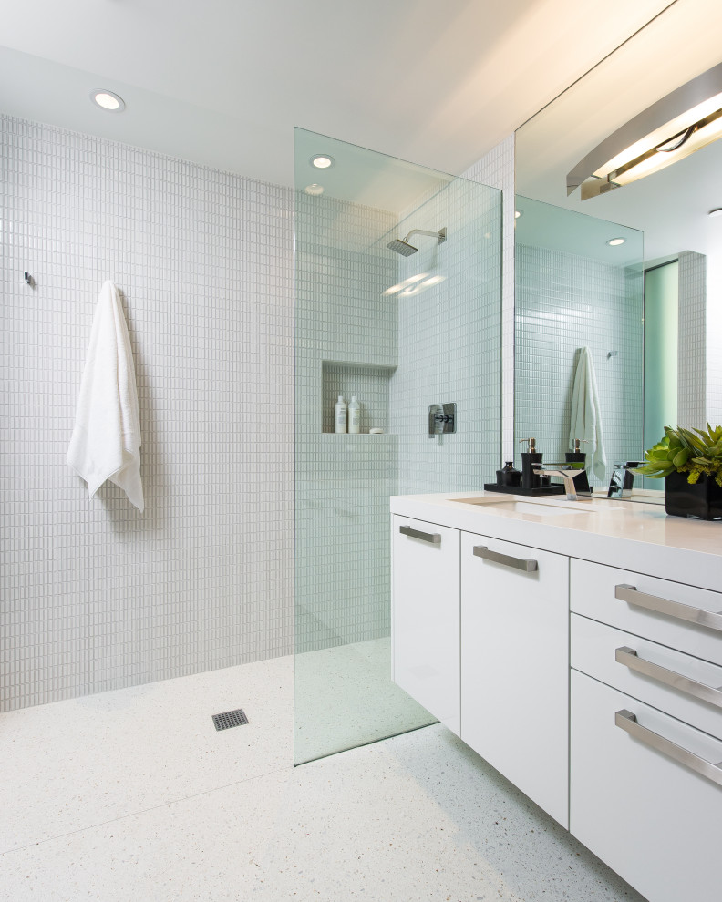 Inspiration för ett stort funkis vit vitt badrum med dusch, med släta luckor, vita skåp, en dusch i en alkov, vit kakel, terrazzogolv, ett undermonterad handfat och vitt golv