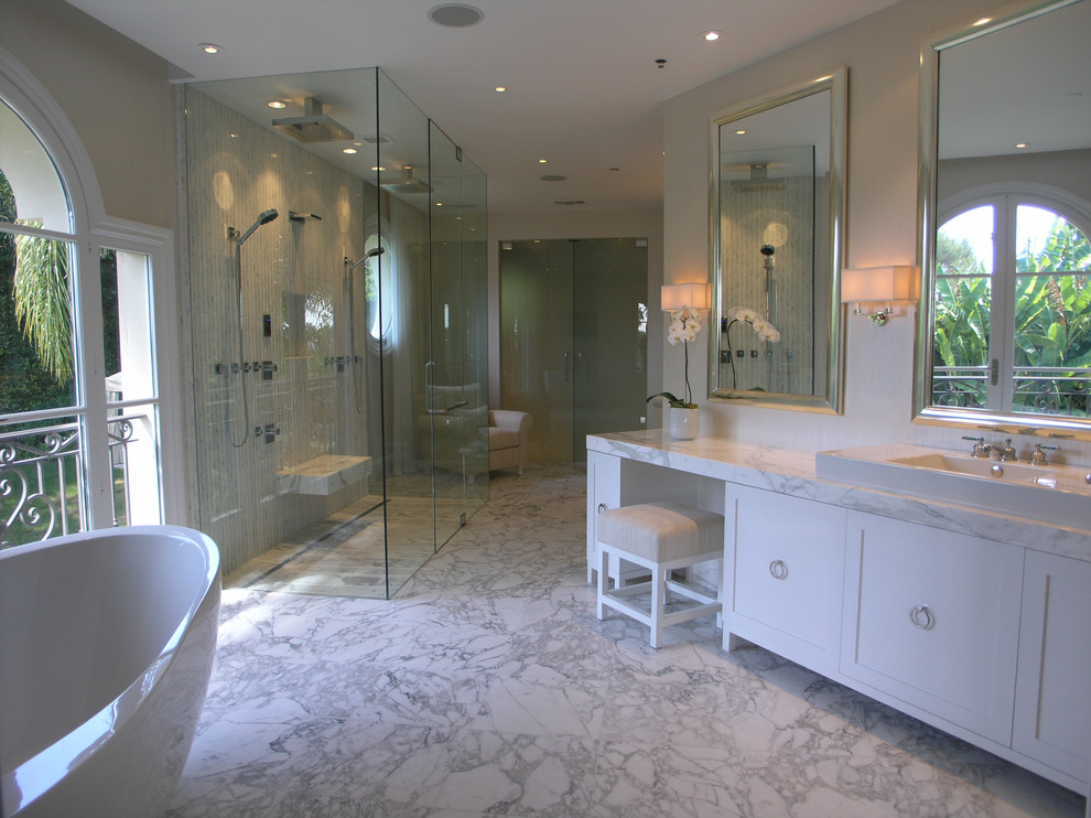 Idée de décoration pour une grande salle de bain principale design avec un placard à porte shaker, des portes de placard blanches, une baignoire indépendante, une douche à l'italienne, un carrelage gris, un carrelage blanc, du carrelage en marbre, un mur beige, un sol en marbre, une vasque et un plan de toilette en marbre.