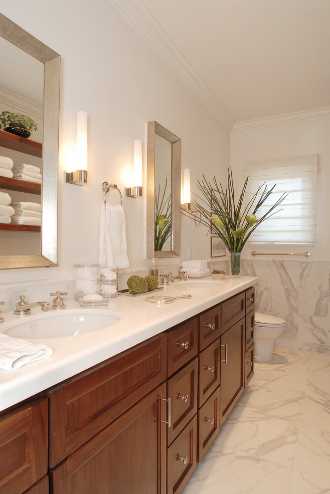 Idées déco pour une salle de bain classique en bois brun avec un lavabo encastré, un placard avec porte à panneau encastré et un carrelage blanc.