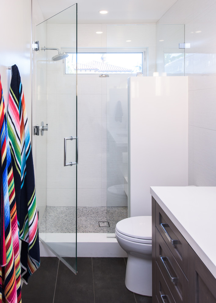 Klassisk inredning av ett mellanstort en-suite badrum, med luckor med infälld panel, grå skåp, en dusch i en alkov, en toalettstol med hel cisternkåpa, vit kakel, vita väggar, ett undermonterad handfat, svart golv och dusch med gångjärnsdörr