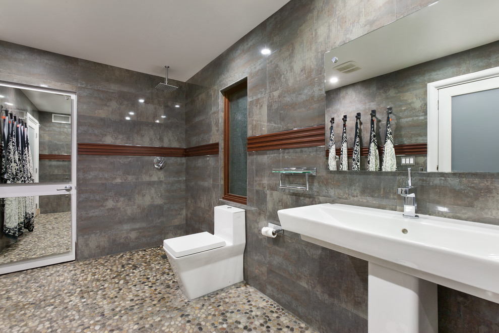 Idée de décoration pour une grande salle de bain principale design avec WC à poser, un mur gris, un sol en galet, une grande vasque, une douche ouverte et aucune cabine.