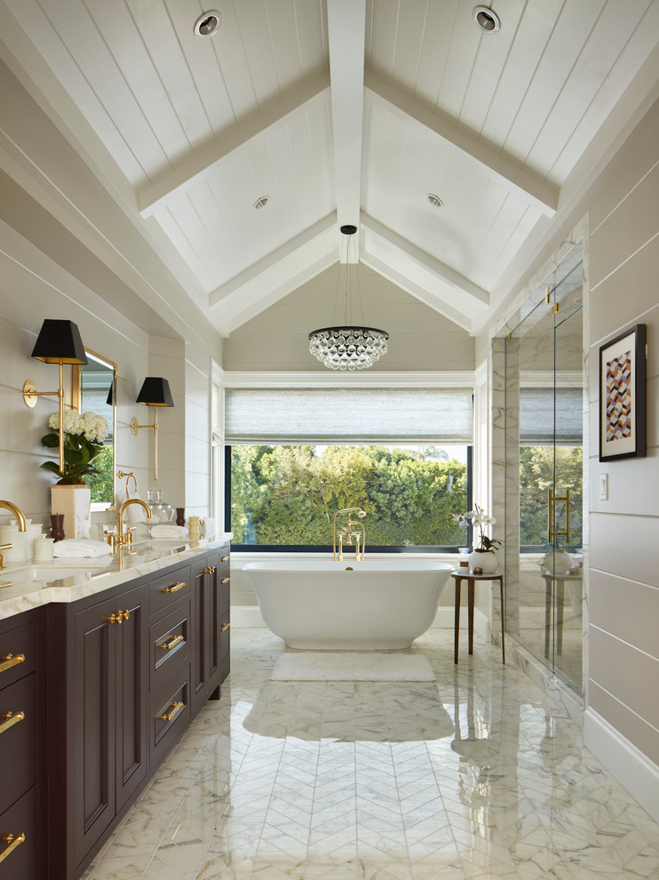 Стильный дизайн: главная ванная комната среднего размера в классическом стиле с фиолетовыми фасадами, отдельно стоящей ванной, белой плиткой, мраморной плиткой, врезной раковиной, мраморной столешницей, душем с распашными дверями, фасадами с утопленной филенкой, душем в нише, бежевыми стенами и белым полом - последний тренд