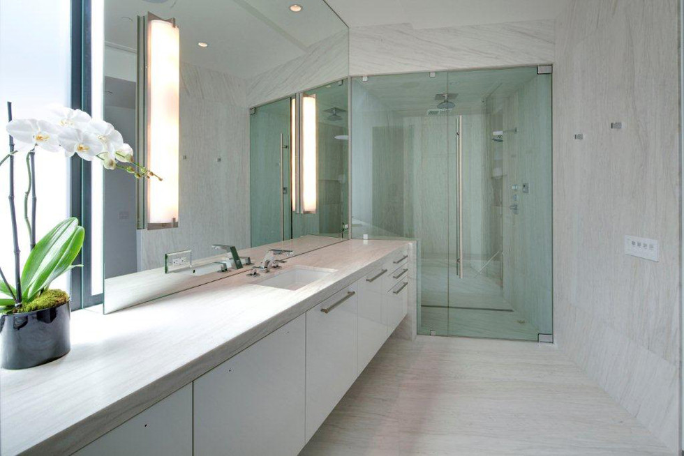 Cette image montre une salle de bain principale minimaliste de taille moyenne avec un carrelage beige, des dalles de pierre, un mur blanc, sol en béton ciré, un lavabo intégré, un plan de toilette en surface solide, un sol blanc et un plan de toilette blanc.