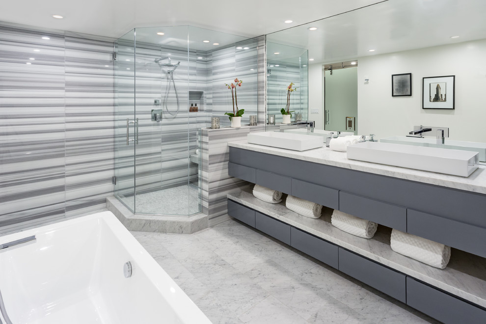 На фото: главная ванная комната в современном стиле с плоскими фасадами, серыми фасадами, угловым душем, серой плиткой, разноцветной плиткой, белой плиткой, настольной раковиной и душем с распашными дверями