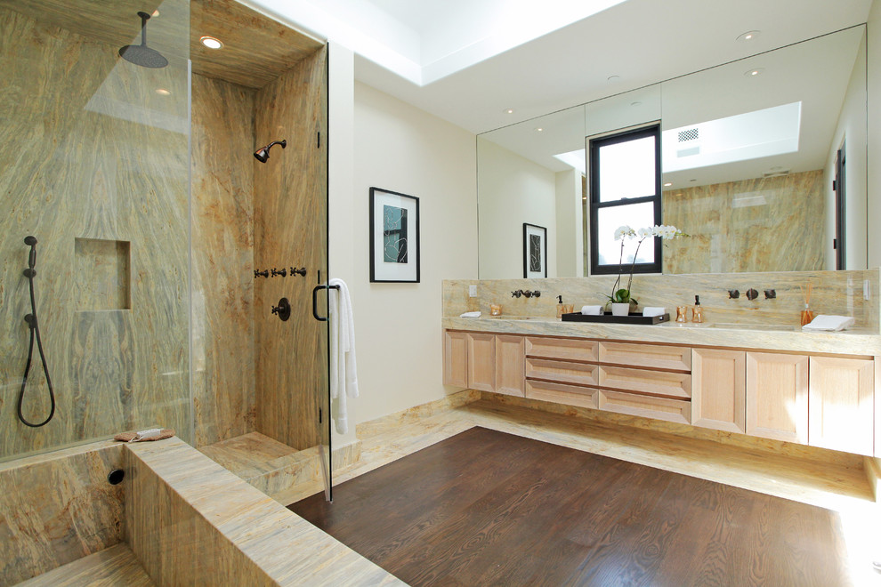 Inspiration pour une grande douche en alcôve principale design en bois clair avec un placard avec porte à panneau encastré, une baignoire indépendante, un carrelage beige, un mur blanc, parquet foncé, un lavabo encastré et un plan de toilette en marbre.