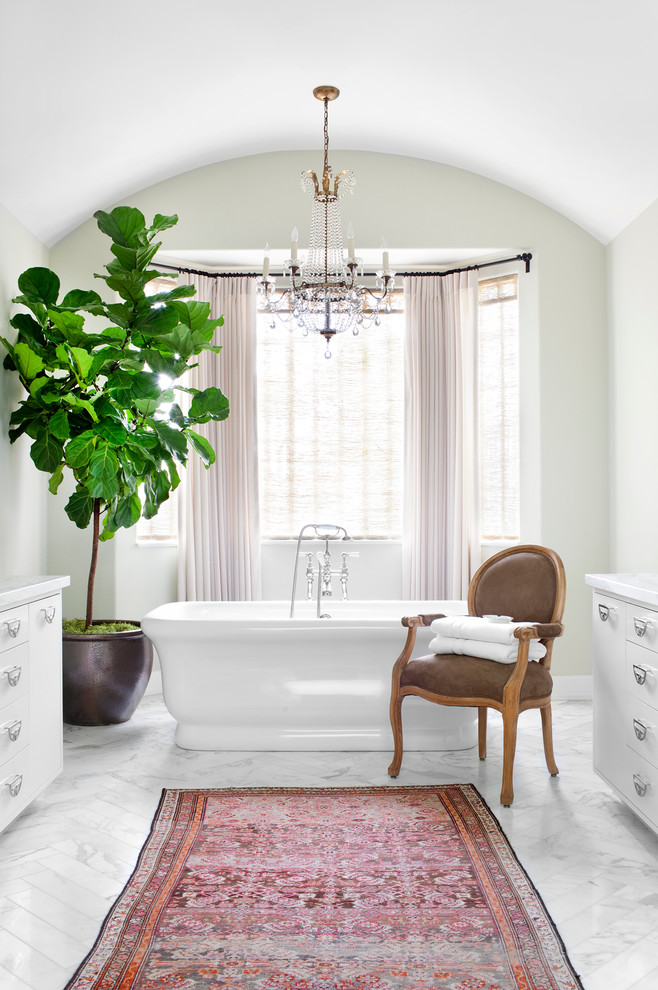 На фото: ванная комната в стиле неоклассика (современная классика) с белыми фасадами, отдельно стоящей ванной, белой плиткой, врезной раковиной и мраморным полом