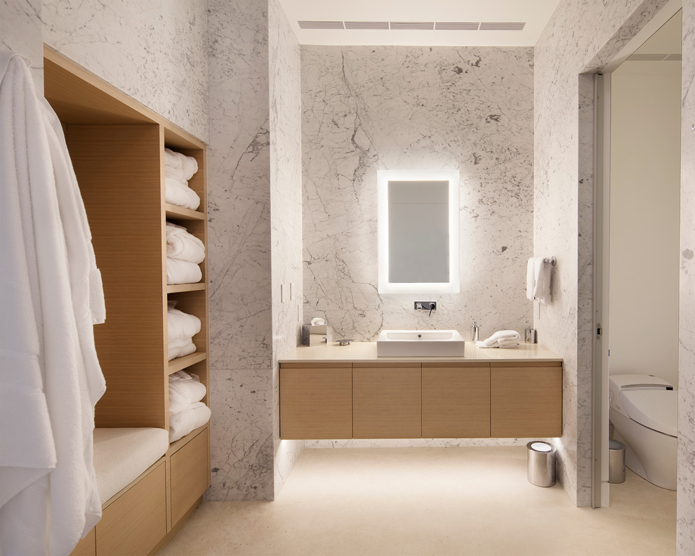 Свежая идея для дизайна: ванная комната в современном стиле с настольной раковиной, плоскими фасадами, светлыми деревянными фасадами, белой плиткой, плиткой из листового камня и зеркалом с подсветкой - отличное фото интерьера