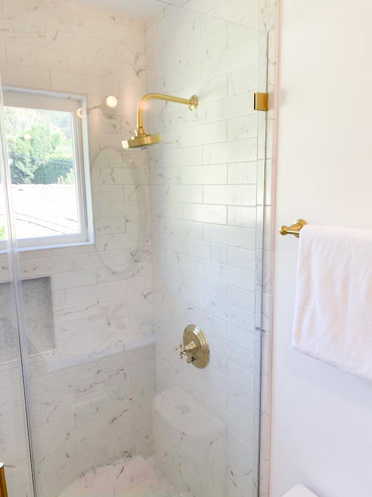 Inredning av ett litet vit vitt badrum med dusch, med vita väggar, en toalettstol med separat cisternkåpa, skåp i shakerstil, svarta skåp, en dusch i en alkov, vit kakel, marmorgolv, bänkskiva i akrylsten, vitt golv och dusch med gångjärnsdörr