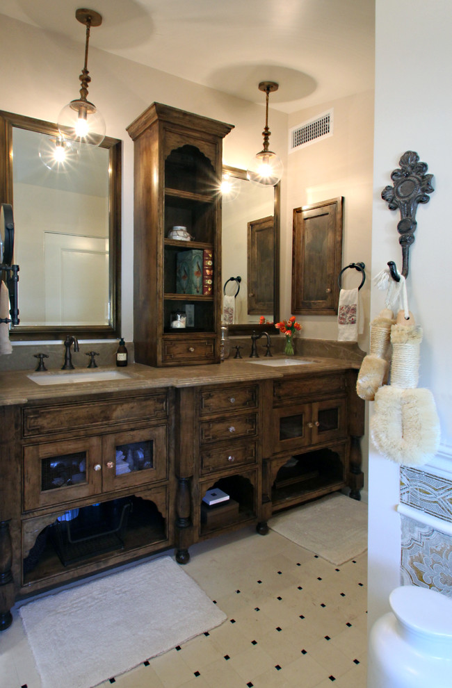 Ejemplo de cuarto de baño principal mediterráneo con lavabo bajoencimera, puertas de armario de madera en tonos medios, encimera de mármol y suelo de piedra caliza