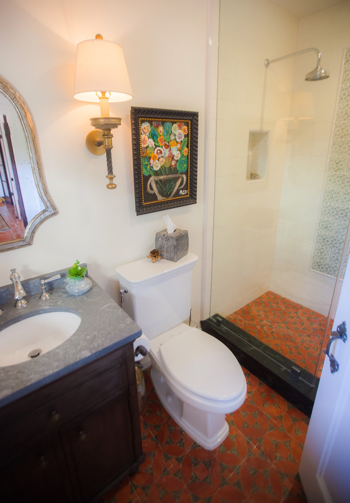 Modelo de cuarto de baño mediterráneo pequeño con lavabo bajoencimera, ducha abierta, sanitario de dos piezas, baldosas y/o azulejos de terracota, paredes blancas y suelo de baldosas de terracota