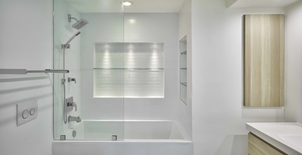 Mid-sized minimalist master white tile and subway tile porcelain tile bathroom photo in Miami with recessed-panel cabinets, light wood cabinets, a wall-mount toilet, white walls, a wall-mount sink and solid surface countertops