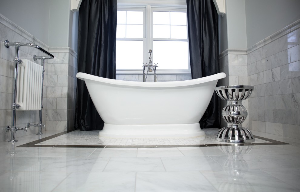 Inredning av ett klassiskt stort en-suite badrum, med ett fristående badkar, stenkakel, marmorgolv, luckor med upphöjd panel, vita skåp, grå kakel, grå väggar, ett undermonterad handfat och marmorbänkskiva