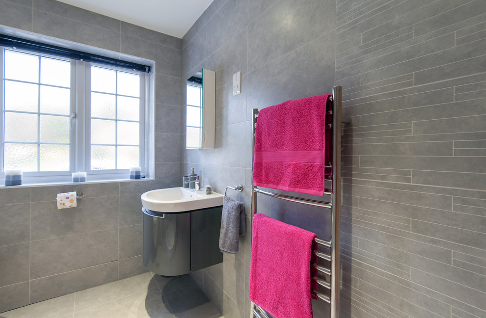 Свежая идея для дизайна: главная ванная комната среднего размера в современном стиле с инсталляцией, серой плиткой, керамогранитной плиткой, серыми стенами, полом из керамогранита и подвесной раковиной - отличное фото интерьера