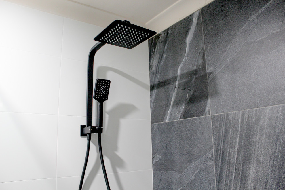 Inspiration för små moderna grått en-suite badrum, med släta luckor, vita skåp, en öppen dusch, en toalettstol med hel cisternkåpa, vit kakel, keramikplattor, svarta väggar, klinkergolv i porslin, ett fristående handfat, bänkskiva i kvarts, grått golv och med dusch som är öppen