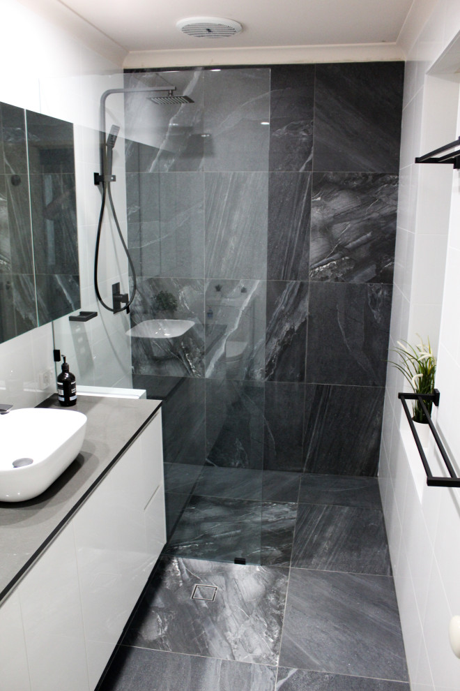 Источник вдохновения для домашнего уюта: маленькая главная ванная комната в стиле модернизм с плоскими фасадами, белыми фасадами, открытым душем, унитазом-моноблоком, белой плиткой, керамической плиткой, черными стенами, полом из керамогранита, настольной раковиной, столешницей из искусственного кварца, серым полом, открытым душем и серой столешницей для на участке и в саду