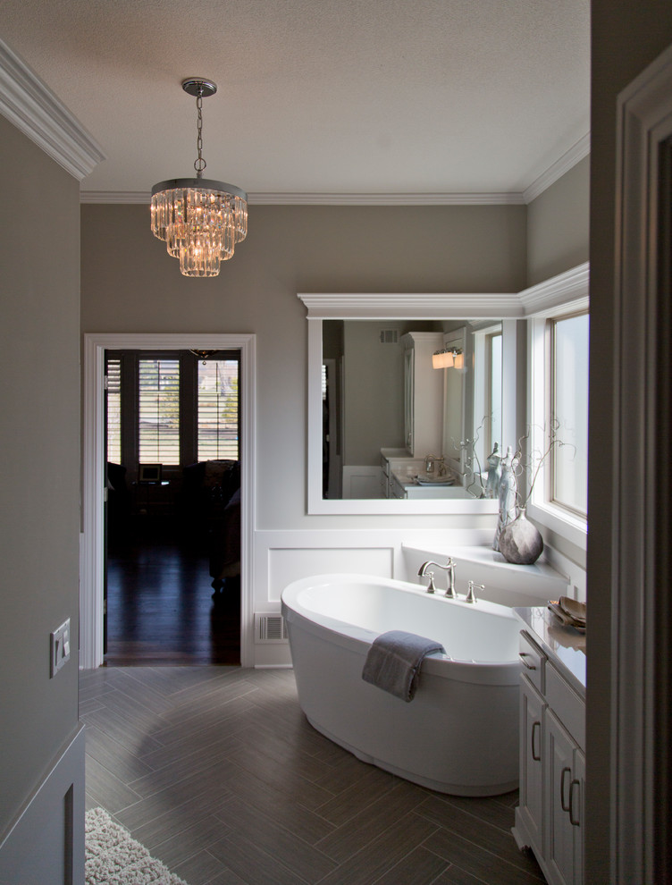 This is an example of a large modern ensuite bathroom in Kansas City with louvered cabinets, white cabinets, a freestanding bath, grey walls, light hardwood flooring and grey floors.