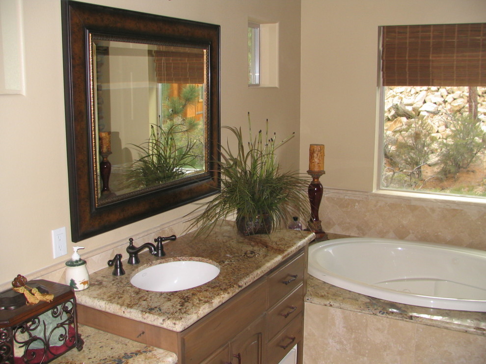 Example of a mid-sized mountain style master beige tile and stone tile travertine floor bathroom design in Los Angeles with raised-panel cabinets, distressed cabinets, a two-piece toilet, beige walls, an undermount sink and granite countertops