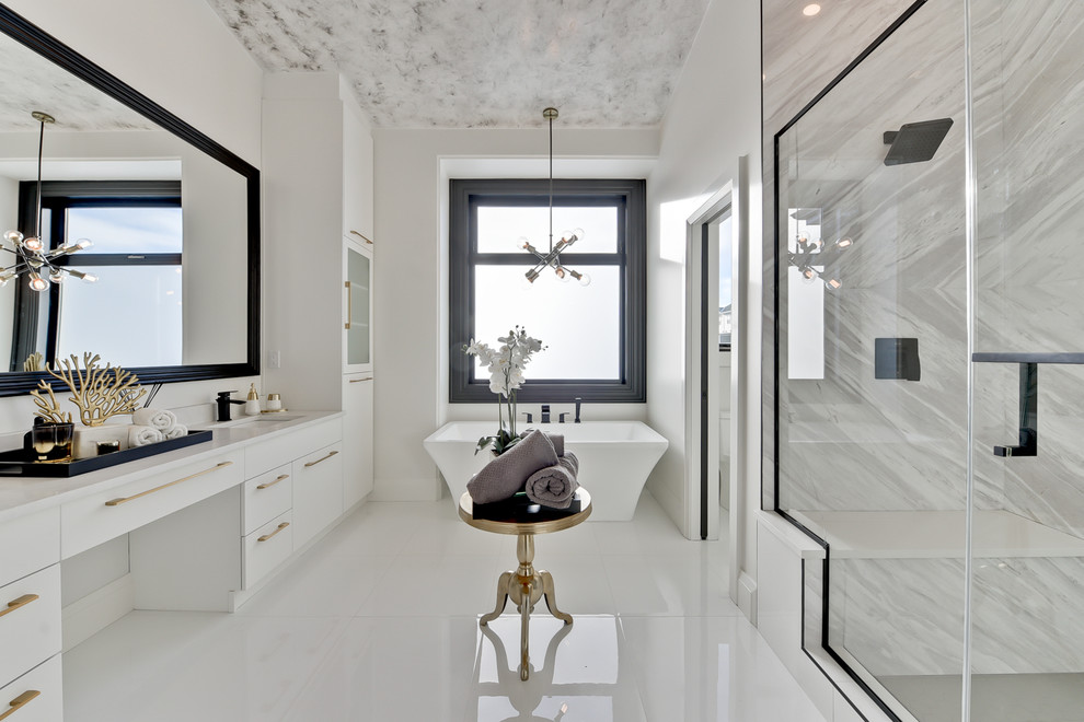 Large contemporary ensuite bathroom in Edmonton with flat-panel cabinets, white cabinets, a freestanding bath, an alcove shower, grey tiles, marble tiles, white walls, ceramic flooring, a submerged sink, engineered stone worktops, white floors, a hinged door and white worktops.