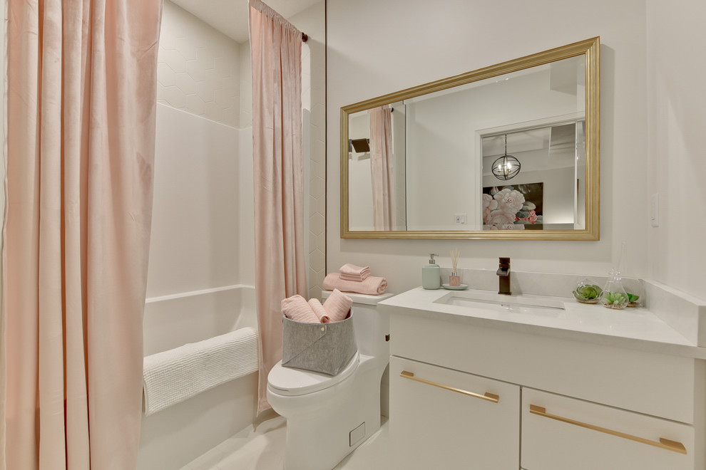 Пример оригинального дизайна: большая ванная комната в современном стиле с плоскими фасадами, белыми фасадами, душем над ванной, унитазом-моноблоком, белой плиткой, керамической плиткой, белыми стенами, полом из керамической плитки, врезной раковиной, столешницей из искусственного кварца, белым полом и шторкой для ванной