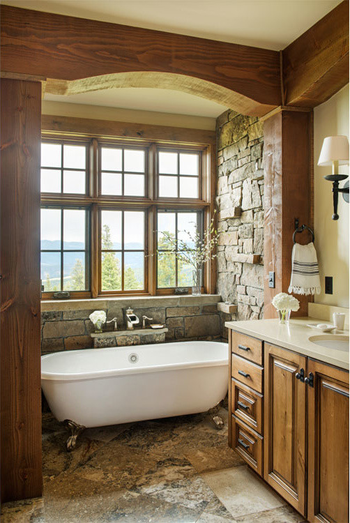 Foto de cuarto de baño rural grande con armarios con paneles empotrados, puertas de armario de madera oscura y bañera con patas