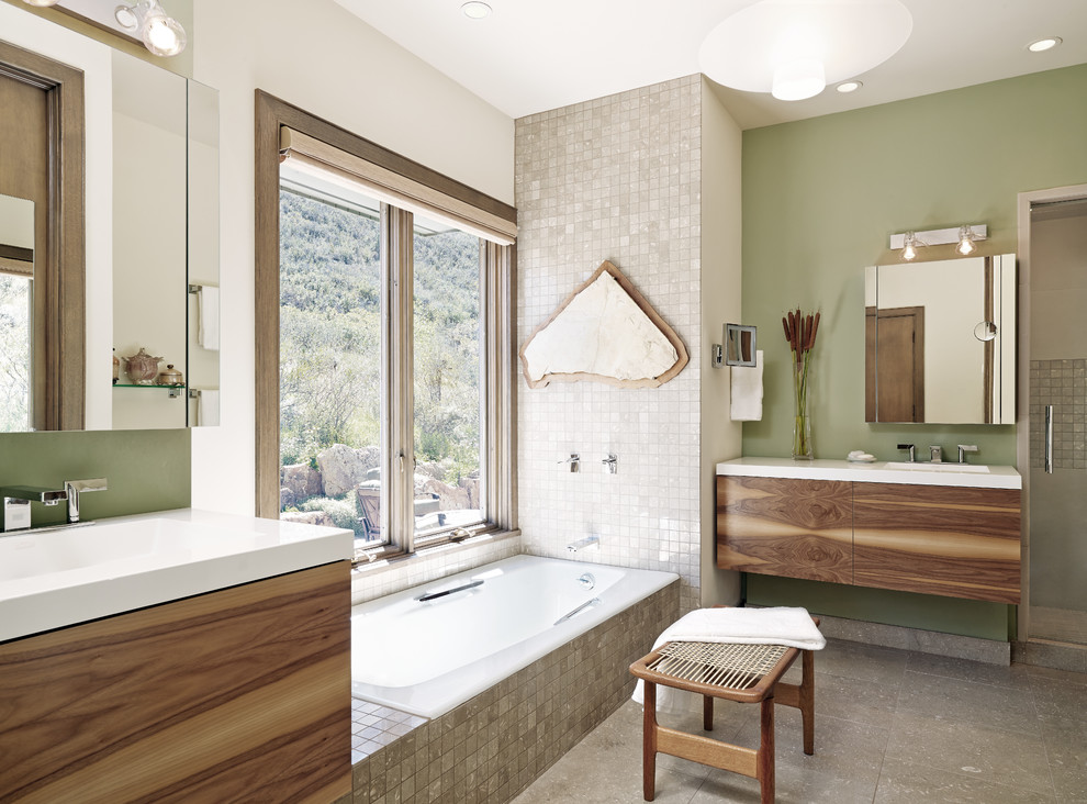 Свежая идея для дизайна: главная ванная комната среднего размера в современном стиле с монолитной раковиной, плоскими фасадами, темными деревянными фасадами, столешницей из искусственного камня, накладной ванной, серой плиткой, каменной плиткой, зелеными стенами, полом из известняка, душем в нише, серым полом и душем с распашными дверями - отличное фото интерьера