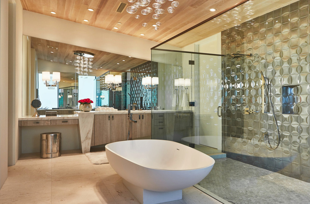 Cette image montre une grande salle de bain principale design en bois brun avec un placard à porte plane, une baignoire indépendante, une douche double, un carrelage gris, carrelage en métal, un mur beige, un sol en calcaire, un lavabo encastré et un plan de toilette en quartz.