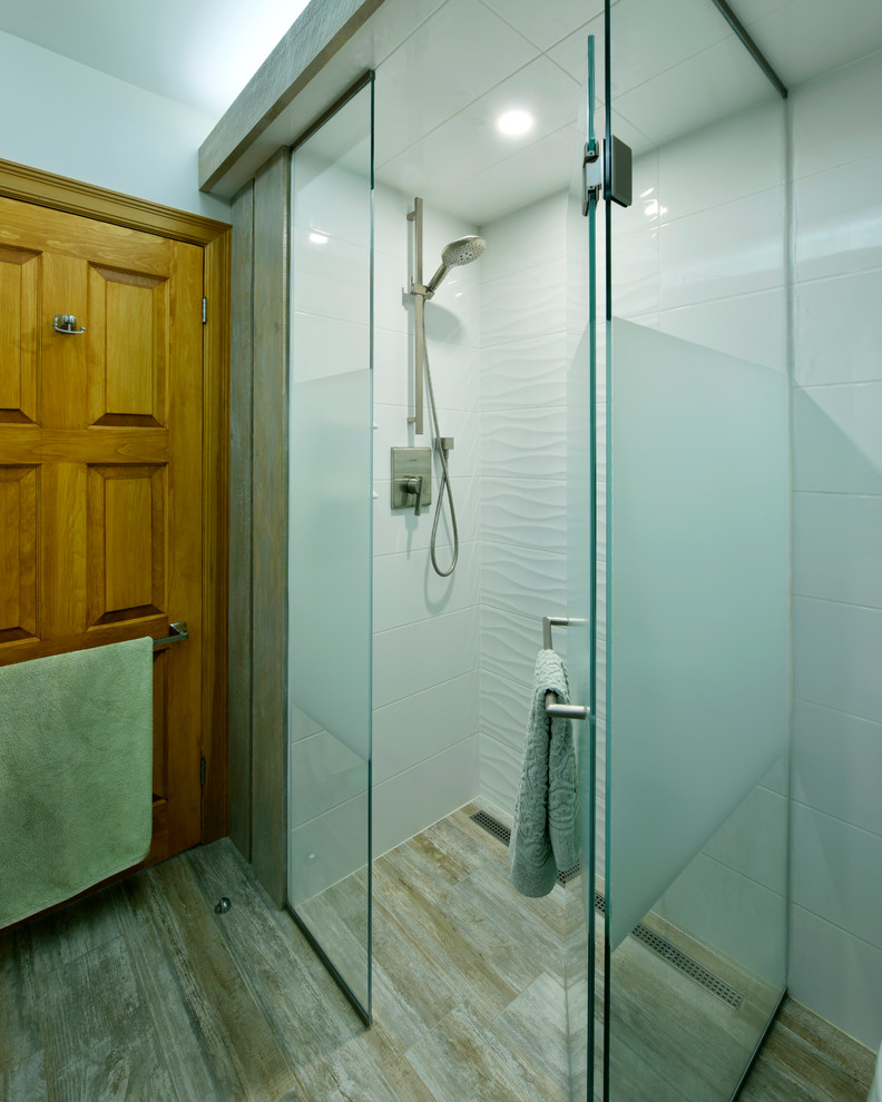 Exempel på ett mellanstort medelhavsstil badrum med dusch, med släta luckor, vita skåp, en toalettstol med hel cisternkåpa, ett platsbyggt badkar, en öppen dusch, grå kakel, vit kakel, stenhäll, blå väggar, målat trägolv, ett nedsänkt handfat, granitbänkskiva och med dusch som är öppen