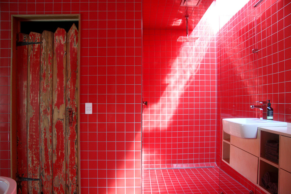 ホバートにあるお手頃価格の広いカントリー風のおしゃれなマスターバスルーム (オープンシェルフ、淡色木目調キャビネット、置き型浴槽、オープン型シャワー、一体型トイレ	、赤いタイル、セラミックタイル、赤い壁、セラミックタイルの床、オーバーカウンターシンク、木製洗面台、赤い床、オープンシャワー) の写真