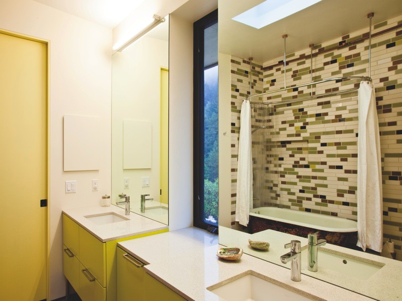 На фото: ванная комната среднего размера в современном стиле с врезной раковиной, плоскими фасадами, желтыми фасадами, ванной на ножках, душем над ванной и инсталляцией с
