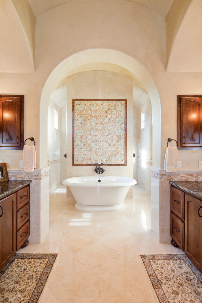 Foto de cuarto de baño mediterráneo con bañera exenta, encimera de granito y piedra