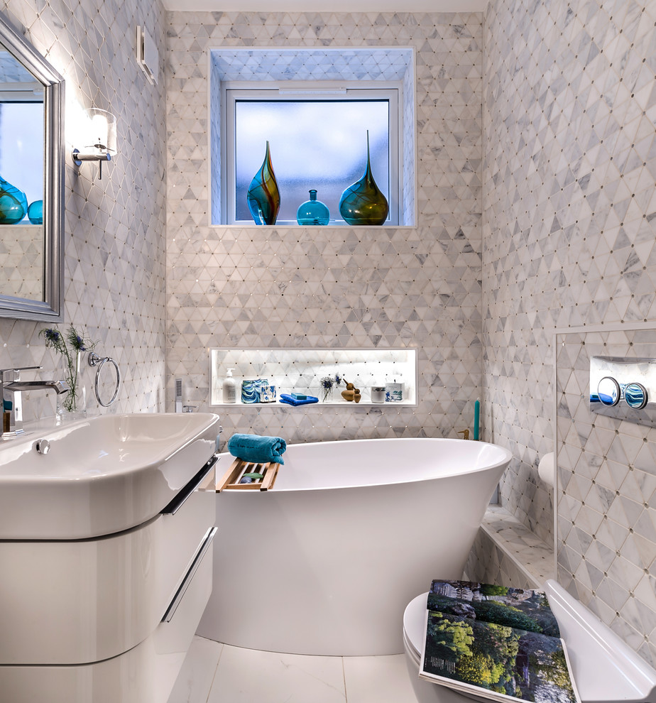 Ispirazione per una piccola stanza da bagno per bambini moderna con vasca freestanding, piastrelle bianche, piastrelle di marmo, pavimento in gres porcellanato, lavabo sospeso e pavimento bianco