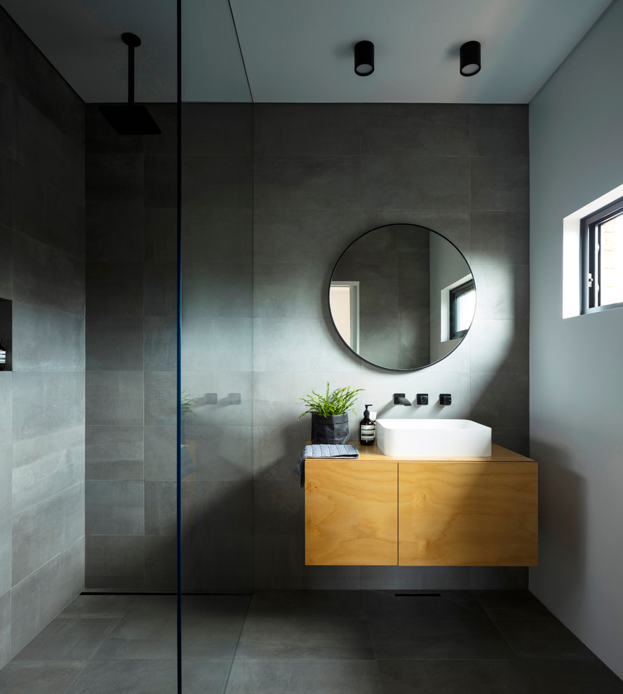 Modernes Duschbad mit flächenbündigen Schrankfronten, hellbraunen Holzschränken, Nasszelle, grauen Fliesen, grauer Wandfarbe, Aufsatzwaschbecken, Waschtisch aus Holz, grauem Boden und brauner Waschtischplatte in Sydney