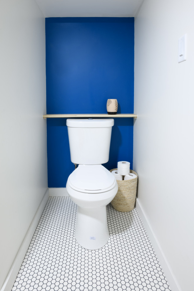 Modern inredning av ett litet en-suite badrum, med en toalettstol med separat cisternkåpa, blå väggar och gult golv