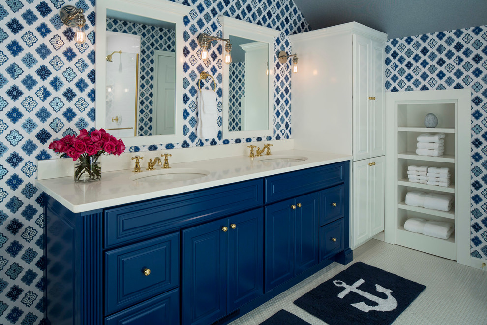 Maritim inredning av ett badrum, med ett undermonterad handfat, luckor med upphöjd panel, blå skåp och flerfärgade väggar