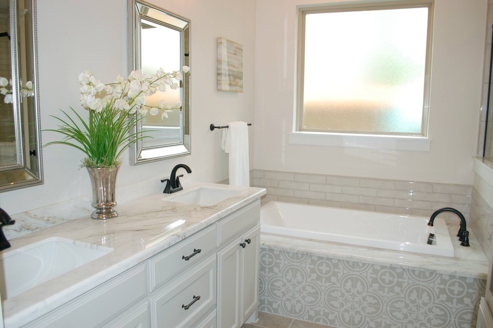Small traditional ensuite bathroom in Dallas with recessed-panel cabinets, beige cabinets, a built-in bath, a corner shower, a one-piece toilet, beige tiles, porcelain tiles, beige walls, ceramic flooring, a submerged sink, granite worktops, beige floors, a hinged door and white worktops.